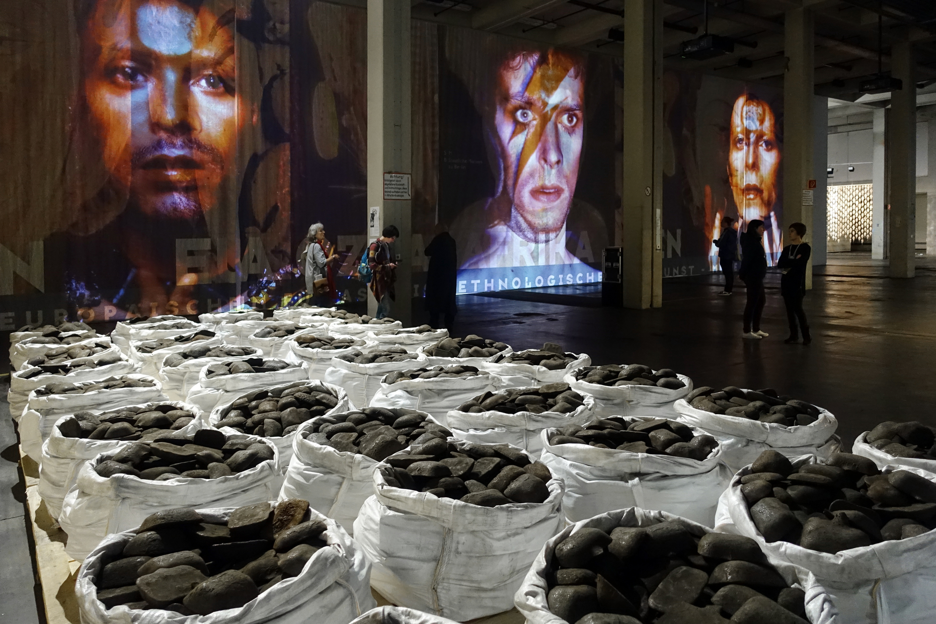 In Neue Galerie: Dan Peterman’s “Kassel Ingot Project (Iron)”, iron ingots as coinage and the brutal reality of German industrial muscle (in the front), and Theo Eshetu’s video installation “Atlas Fractured”.