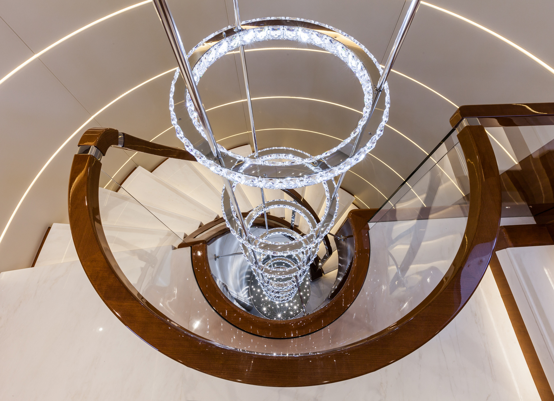 The steel rings studded with Swarovski crystals provide a decorative light sculpture for the spiral-shaped staircase connecting the lower to the upper deck.